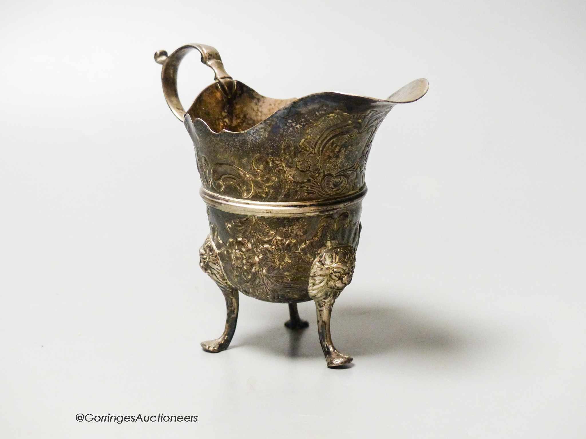 An 18th century Irish? silver cream jug, with later embossed decoration, marks rubbed, height 11.1cm, 4.5oz.